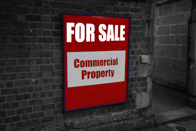 Sign on a building saying Commercial Property for sale indicating a commercial sale