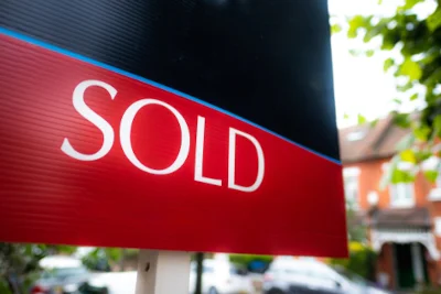Estate,Agent,'sold',Sign,On,Residential,Street Image of a for sale board saying "Sold" through J & J McCosh estate agency